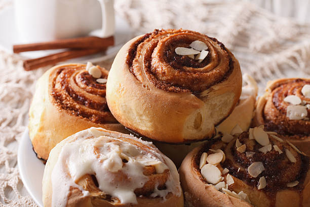 istock Freshly baked cinnamon rolls with icing and almonds macro 619629136