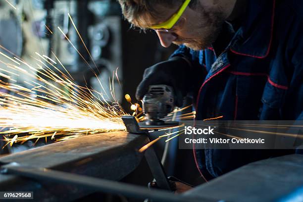 Factory Worker Using Electric Grinder In Metal Industry Stock Photo - Download Image Now