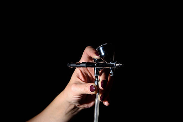 istock female hand holding the airbrush 619633180