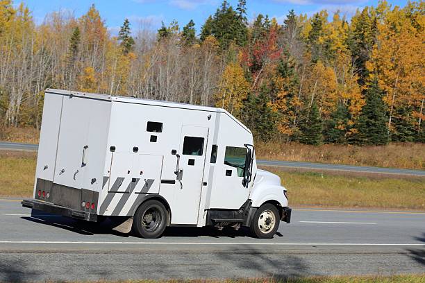 Armored truck on an interstate, trees in background. Armored truck on an interstate, trees in background. armored truck stock pictures, royalty-free photos & images
