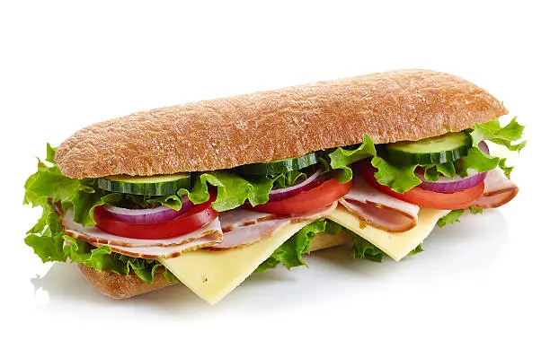 Fresh submarine sandwich with ham, cheese, tomatoes, cucumbers, lettuce and onions isolated on white background