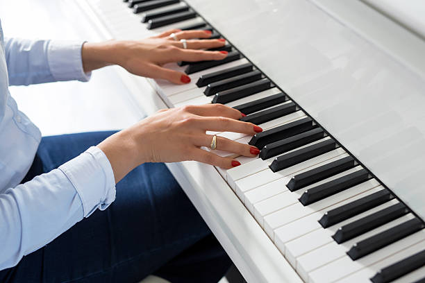 istock Woman playing white piano 619637224