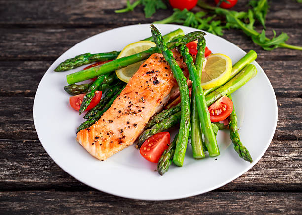 istock Fried salmon with asparagus, tomatoes, lemon, yellow lime on white 619637282