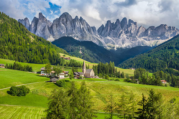 Val di Funes, South Tyrol, Italy Beautiful view of idyllic mountain scenery in the Dolomites with famous Santa Maddelana mountain village on a sunny day with blue sky and clouds in spring, Val di Funes, South Tyrol, northern Italy alto adige italy stock pictures, royalty-free photos & images