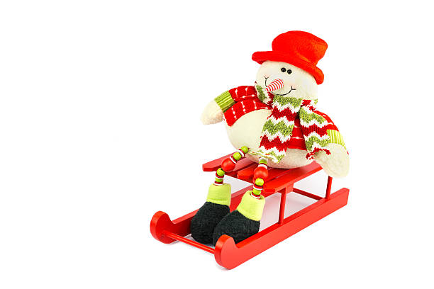 istock Snowman figurine sitting on red sledge 619639148