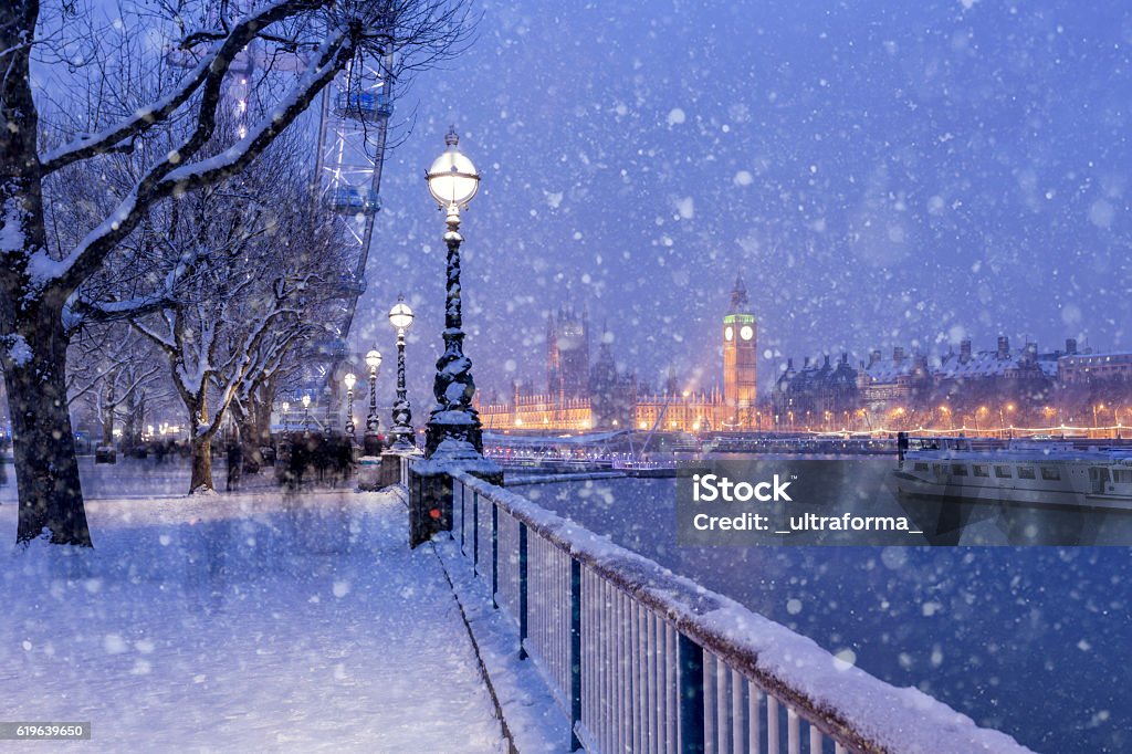 Snowing on Jubilee Gardens in London at dusk View of Jubilee Gardens and Westminster Palace during the winter holidays in London. Christmas Stock Photo