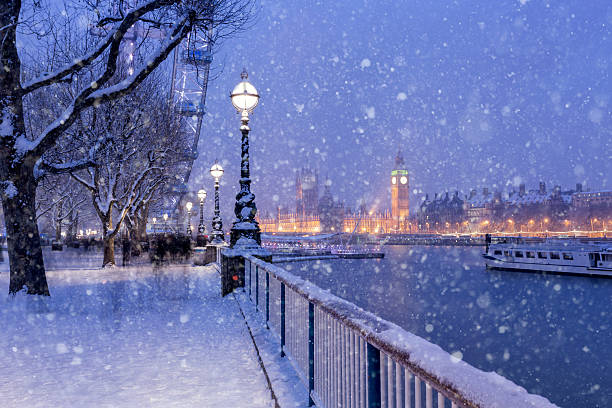 Snowing on Jubilee Gardens in London at dusk View of Jubilee Gardens and Westminster Palace during the winter holidays in London. snowing photos stock pictures, royalty-free photos & images