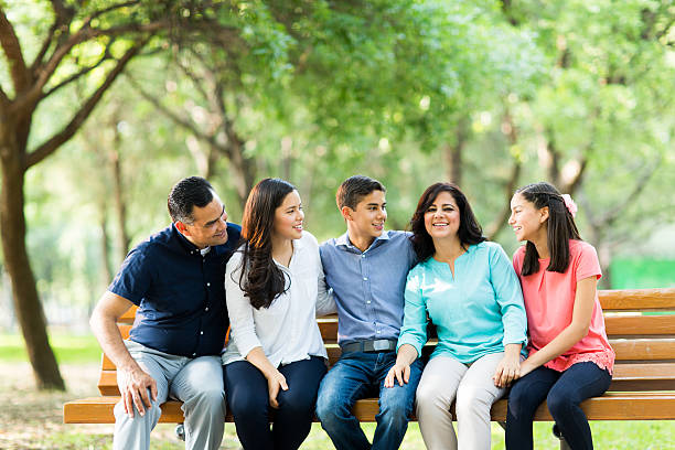 istock Family sitting on a bench and looking at mother 619640276
