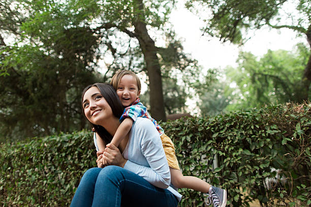 istock Little boy on his mother's back smiling at camera 619641040