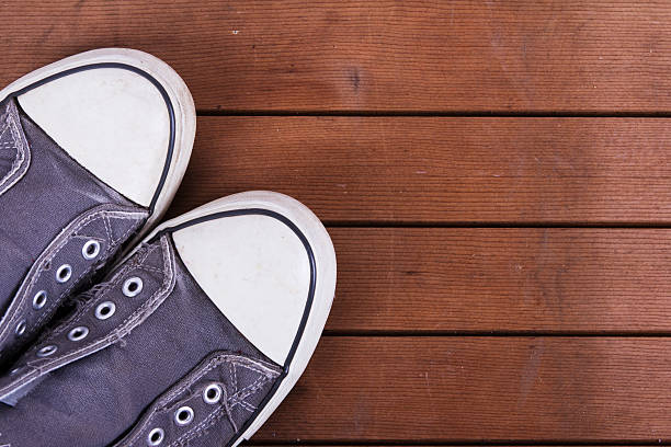 istock Old canvas shoes on a wooden floor 619642472