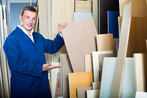 istock Cheerful workman standing with plywood pieces 619642864