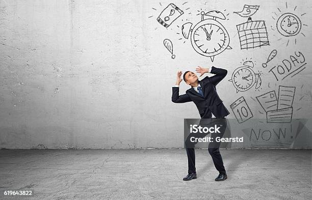 Frightened Businessman Shielding Himself With His Hands From The Drawings Stock Photo - Download Image Now