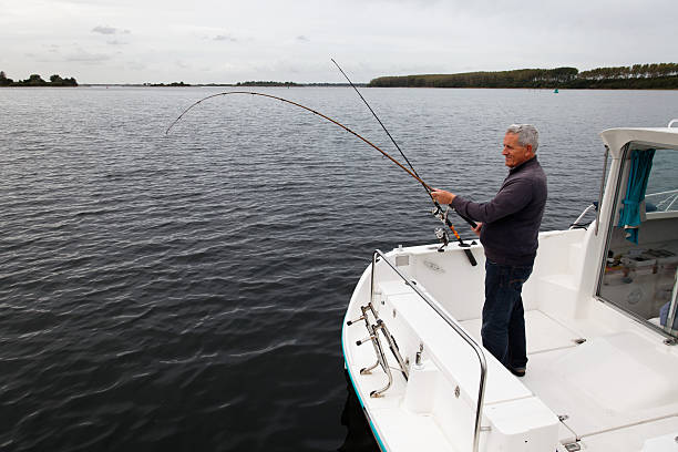 istock fisherman with a white boat on a dark lake 619644568
