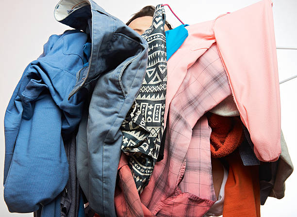 istock man holding pile of clothes 619645610