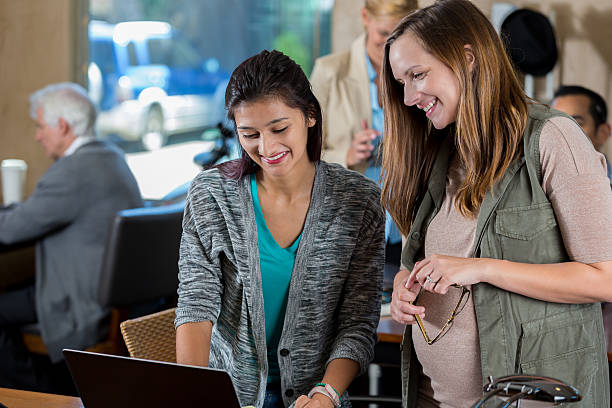 istock IT support employee assists woman with computer 619646330