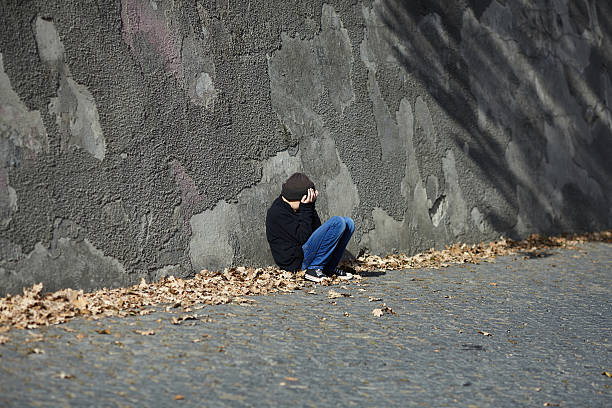 istock young homeless boy sleeping on the street 619647200