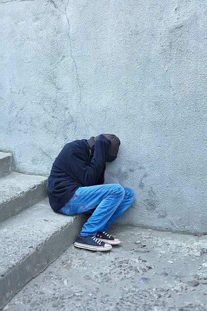 istock young homeless boy sleeping on the street 619647222