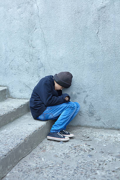 istock young homeless boy sleeping on the street 619647454