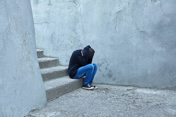istock young homeless boy sleeping on the street 619647532