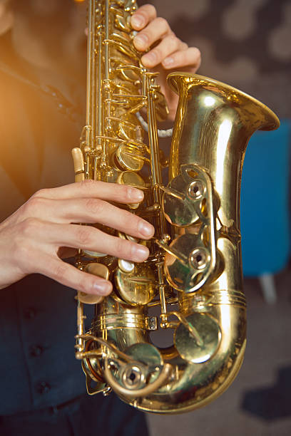 istock Young man in a suit hold saxophone 619647688