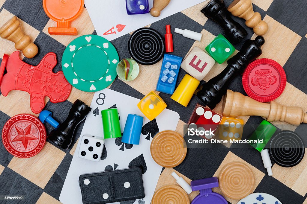 Miscellaneous board game pieces on a chess board Board Game Stock Photo