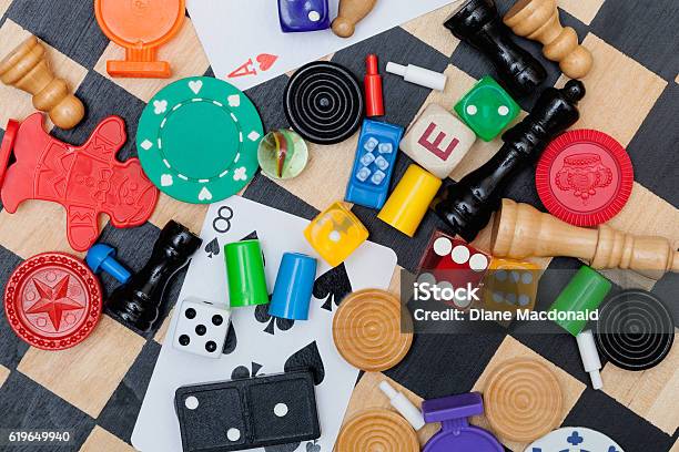 Miscellaneous Board Game Pieces On A Chess Board Stock Photo - Download Image Now - Board Game, Leisure Games, Part Of