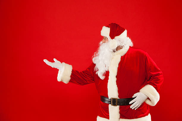 istock Santa Claus pointing in blank a place, red background 619650230