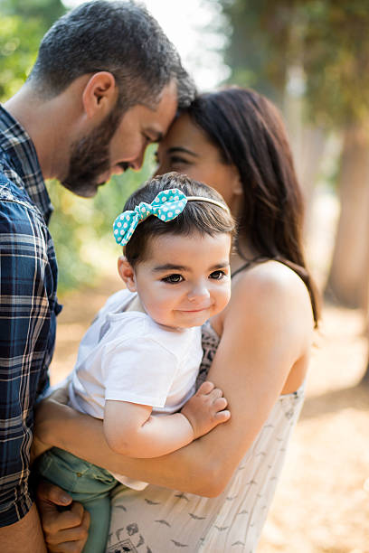 istock Latin parents holding baby daughter between them 619651312