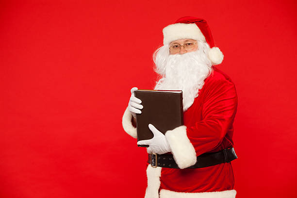 istock Santa Claus reads old book, on a red background. Christmas 619652408