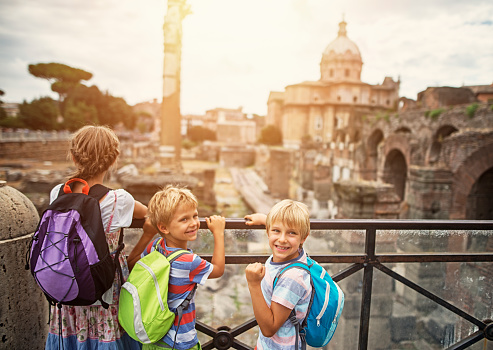 Mother and kids visiting Rome. Excited kids are looking at magnificient Roman Forum.