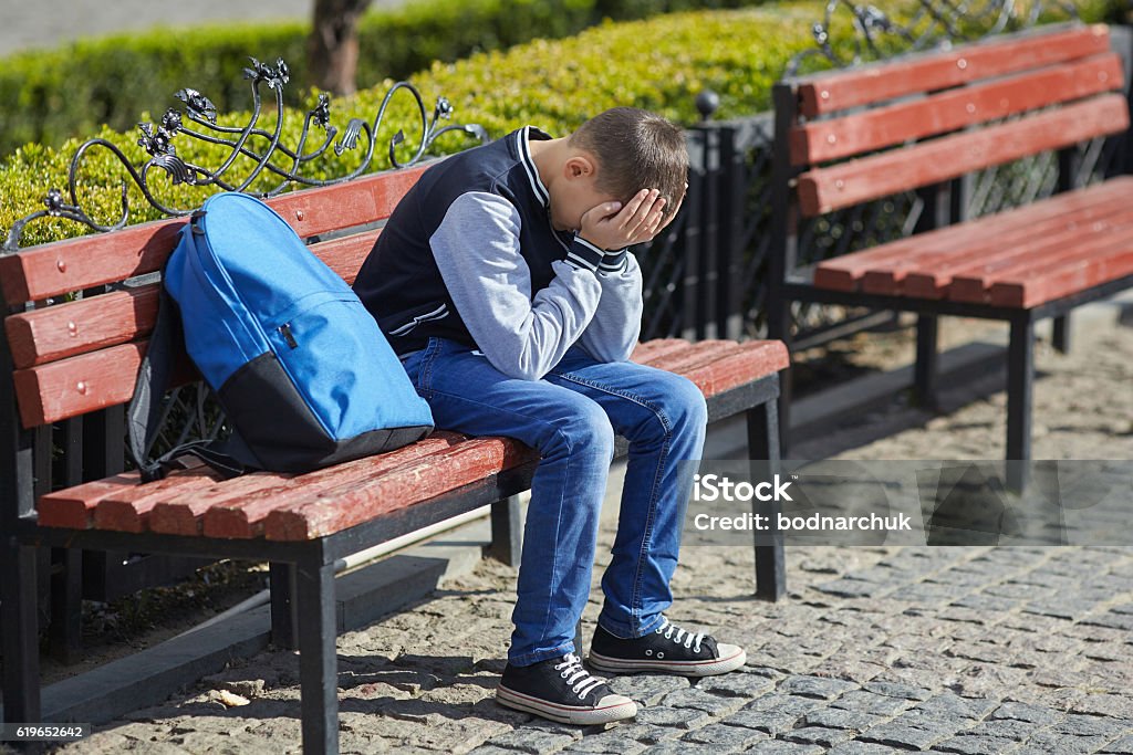 schoolboy crying on the street schoolboy crying on the street, negative emotion Adolescence Stock Photo