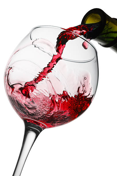 istock red winepouring in glass isolated on the white background 619653088
