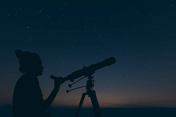 istock Woman with astronomical telescope. Starry night Constellations, 619655704