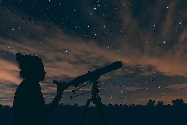 istock Woman with telescope. Night sky, with clouds and constellations, 619655802