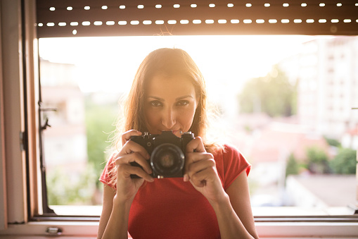 Gorgeous woman holding camera indoors