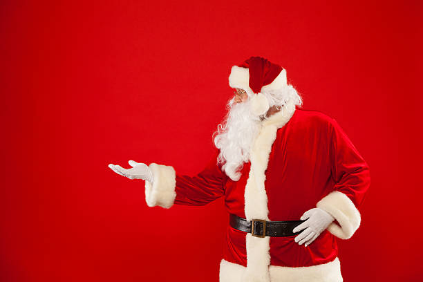 istock Santa Claus pointing in blank a place, red background 619663352