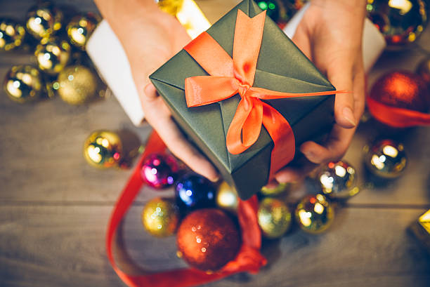 istock man holding a gift box in a gesture of giving 619663406