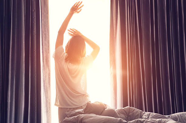 istock Woman stretching near bed after wake up 619664836