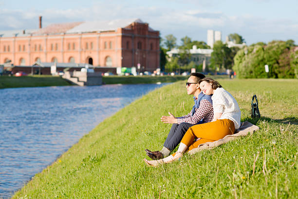The loving couple is sitting on the grass.