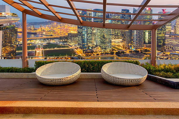 Relax corner on condominium rooftop garden with chairs on Landscape of the Singapore financial district and business building background, Landmark concept