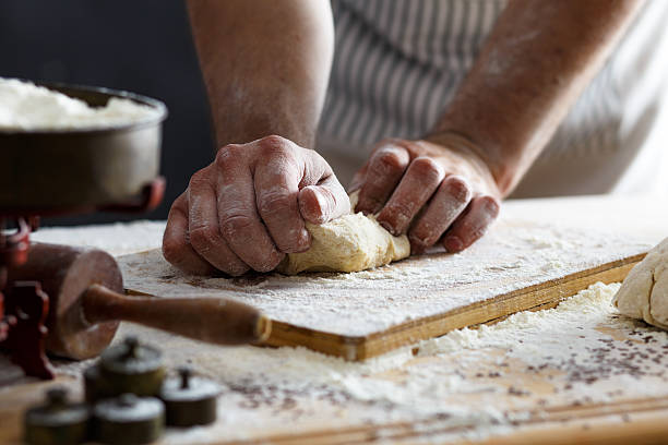 primo piano di ciclisti panettiere mani pasta di impastamento - impastare foto e immagini stock