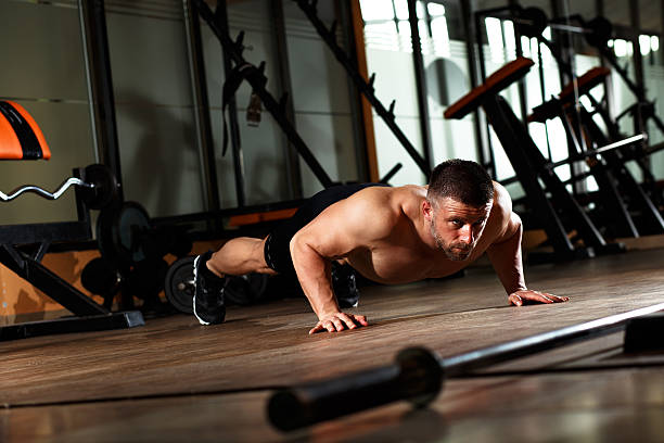 istock Muscular man doing a pushups at gym. 619672656