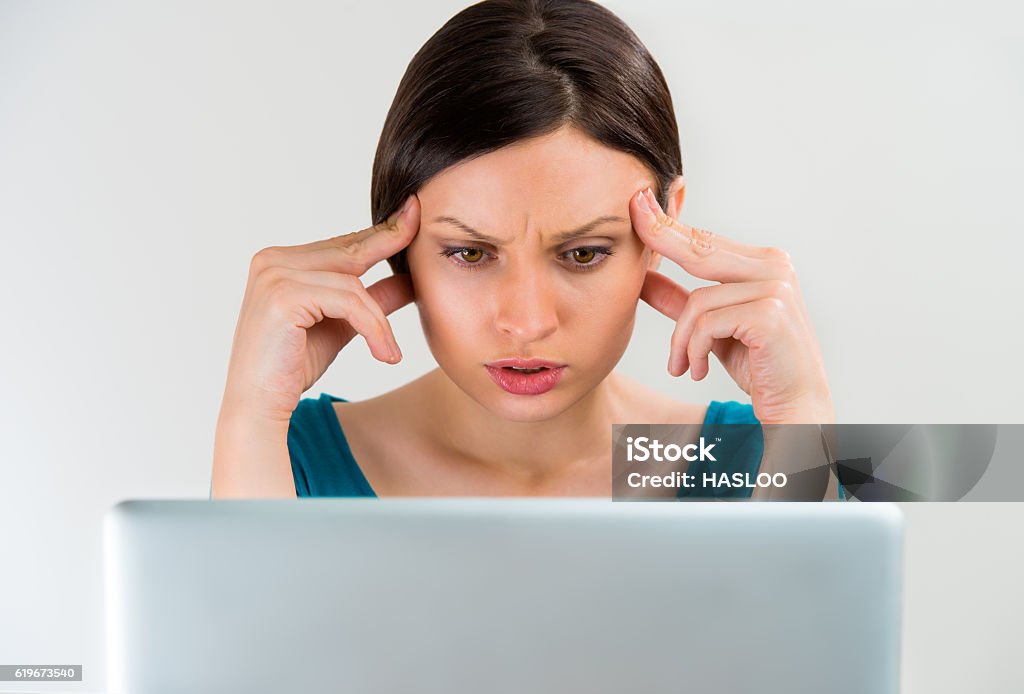 Young woman thinking, working on laptop Young sad serious woman thinking, working on laptop Adult Stock Photo