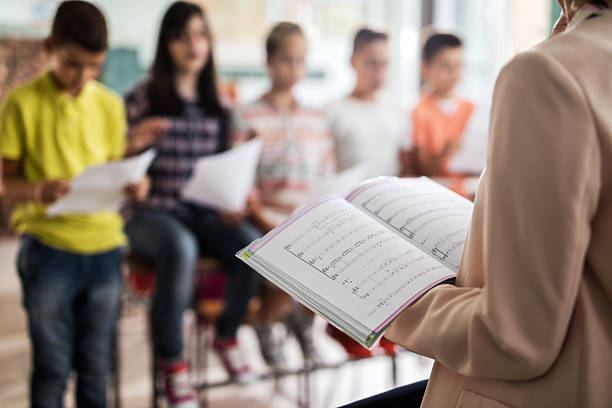 istock Close up of unrecognizable teacher during music lesson. 619674006