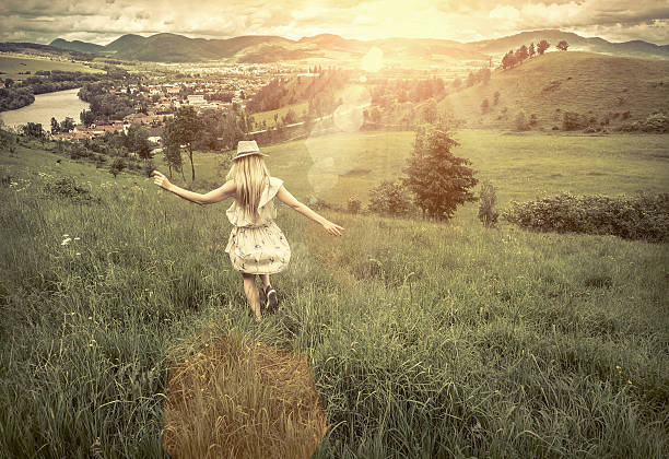 istock Female in hat on the green meadow at sunny day 619675202