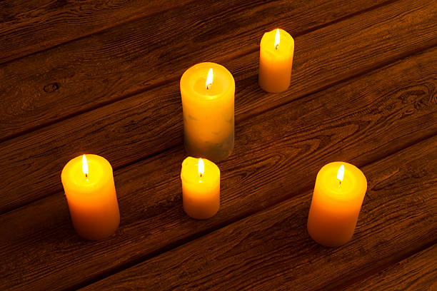istock Candles on old wooden background. 619675568