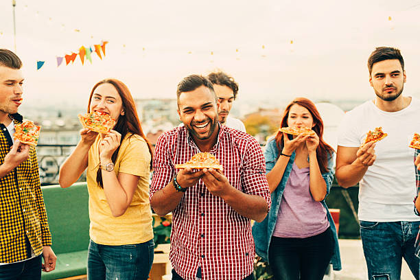 istock Eating pizza at a party on the roof 619675948