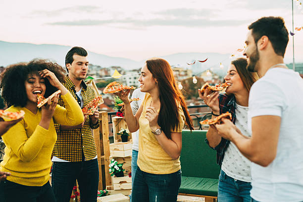 istock Eating pizza at a party on the roof 619676012