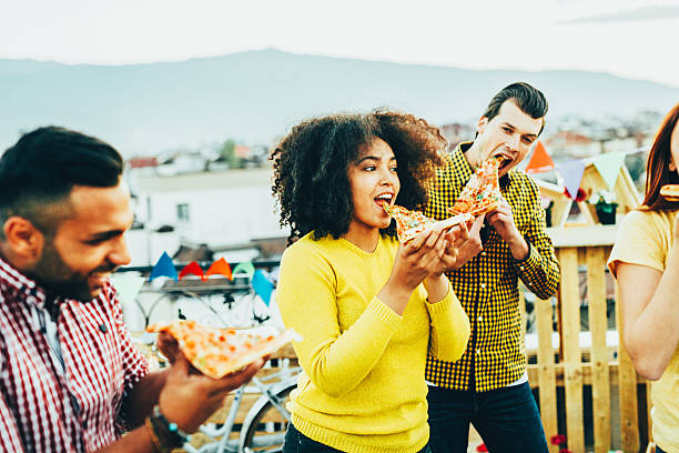 istock Eating pizza at a party on the roof 619676080