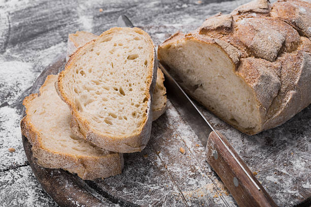 istock Bakery concept background. Knife cutting bread loaf slices 619727322